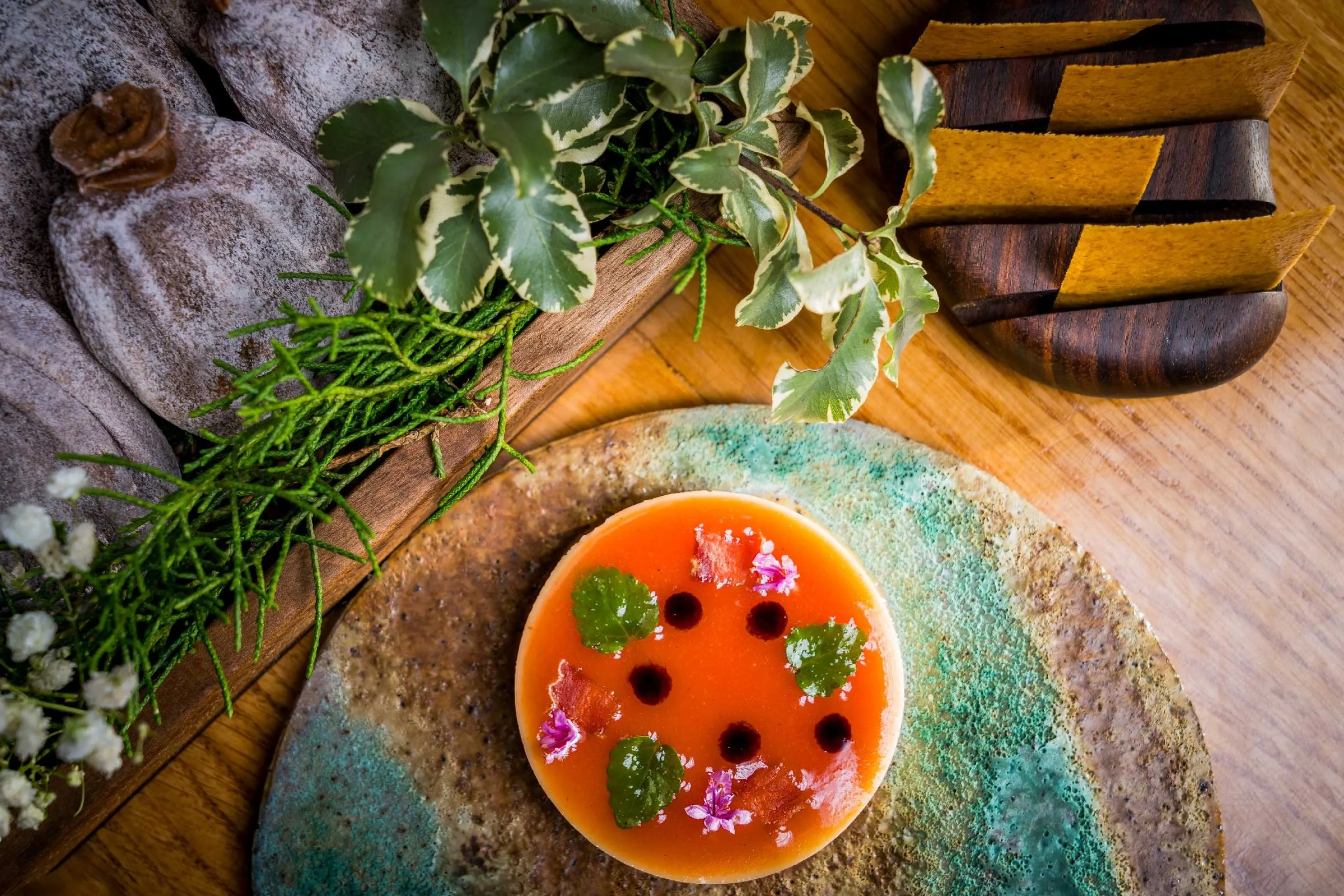An orange plated course on a turquoise-glazed ceramic plate at Amelia by Paulo Airaudo.