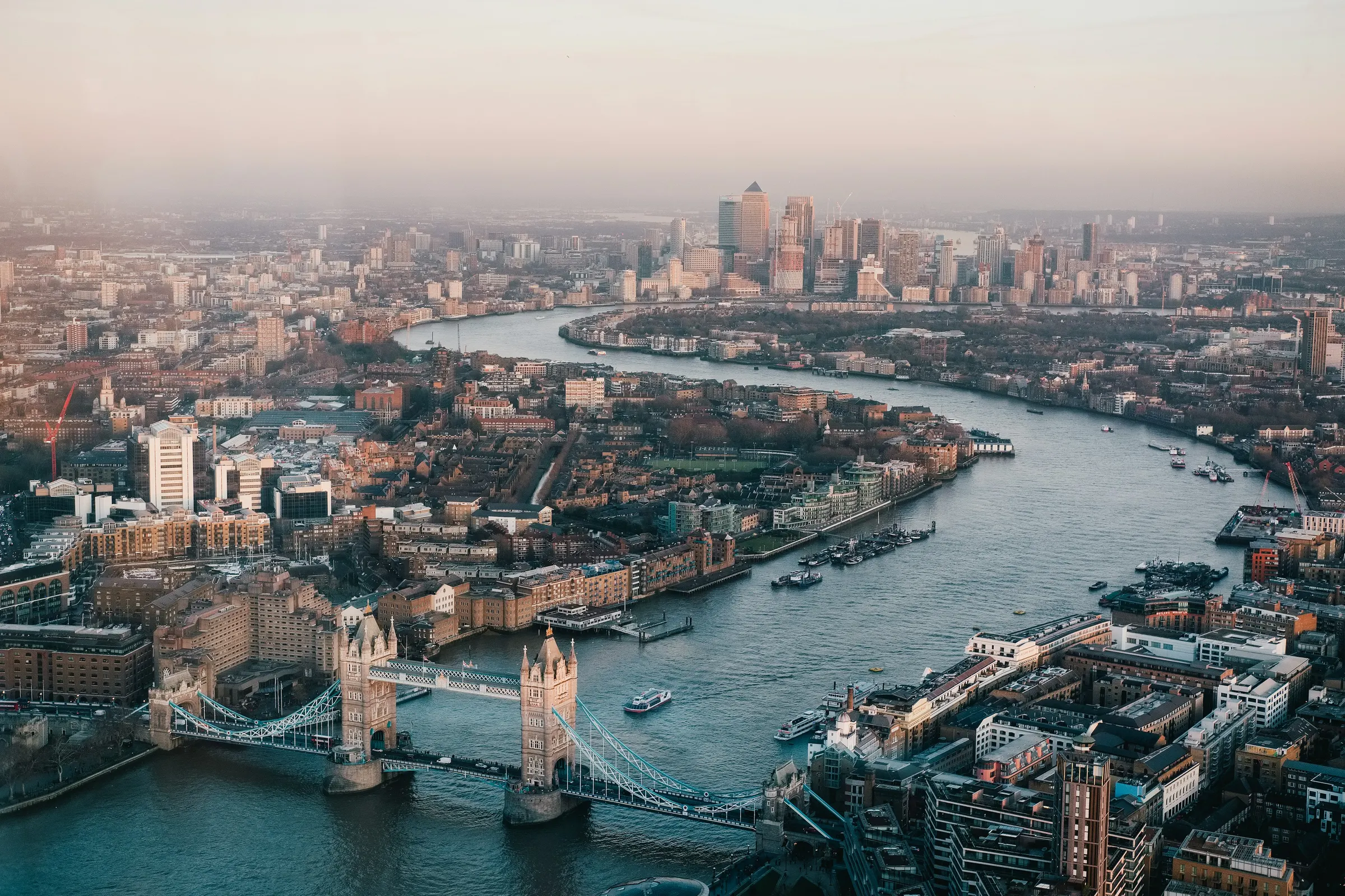 The River Thames and Tower Bridge seen from above, with Canary Wharf beyond.