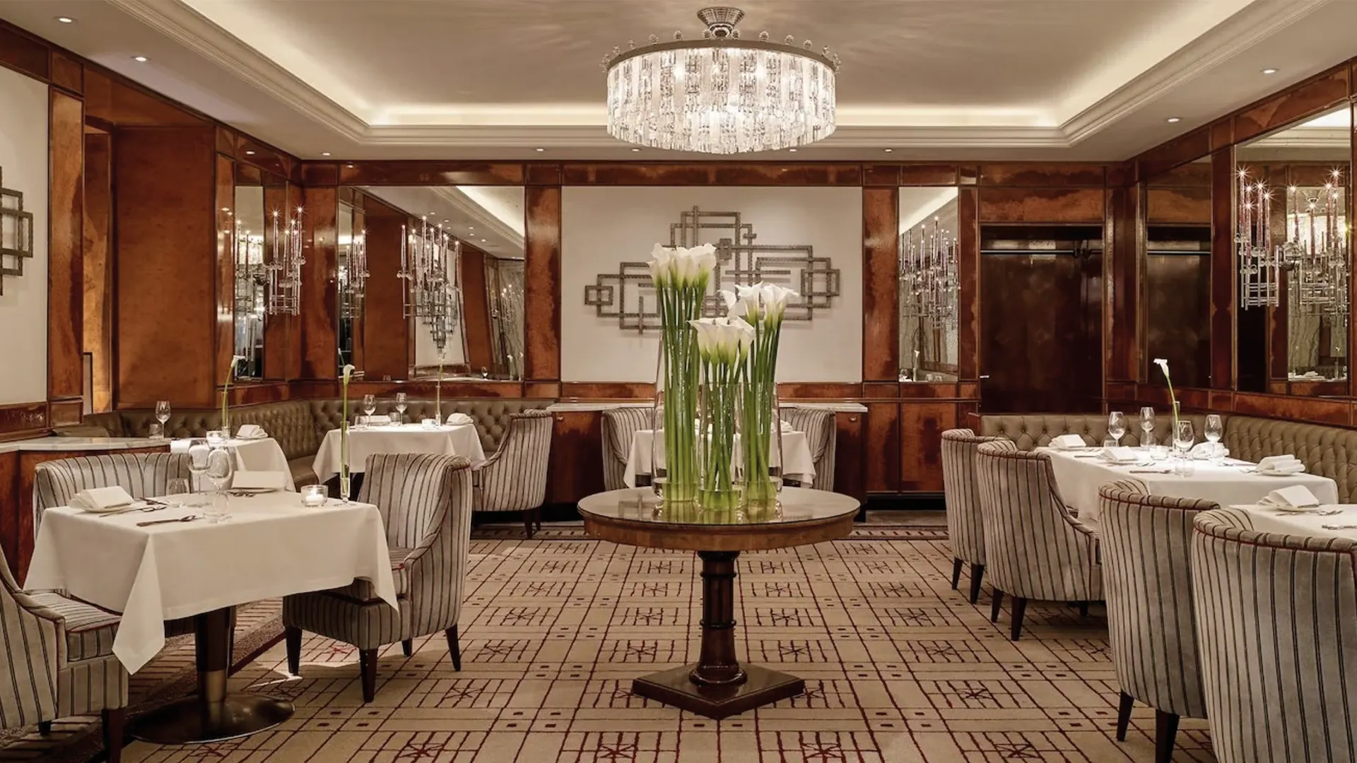 An elegant dining room with white tablecloths and a central floral display.