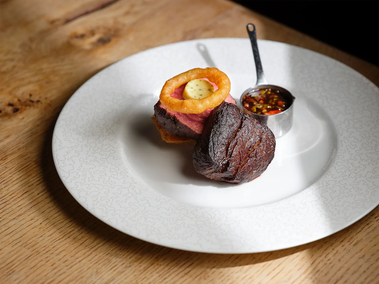 A plated beef dish on a wooden table at The Hand and Flowers