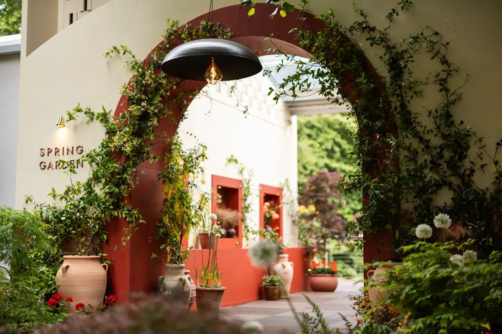 The entrance to the Spring Garden at the Chelsea Flower Show, a terracotta archway hung with greenery.