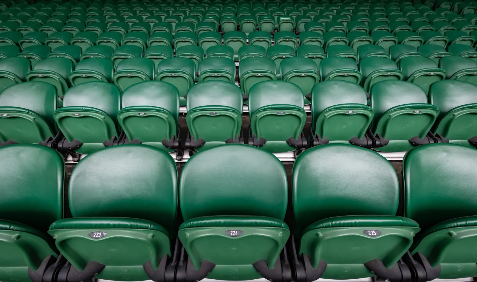 Rows of green seats on Centre Court at Wimbledon.