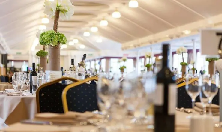 Image of the Pavilion restaurant with flower arrangements, bottles of wine and glasses ready for service