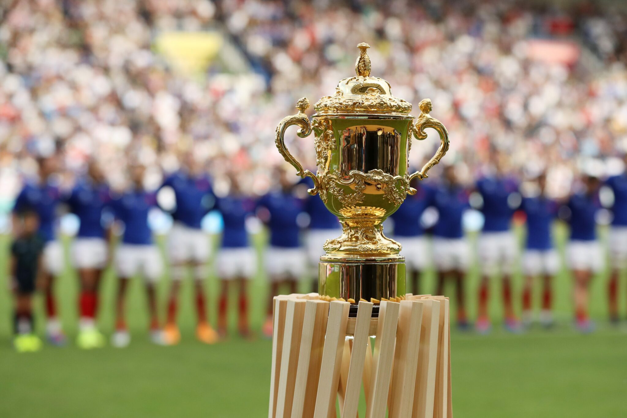 Rugby World Cup trophy on stand in the stadium infront of the players