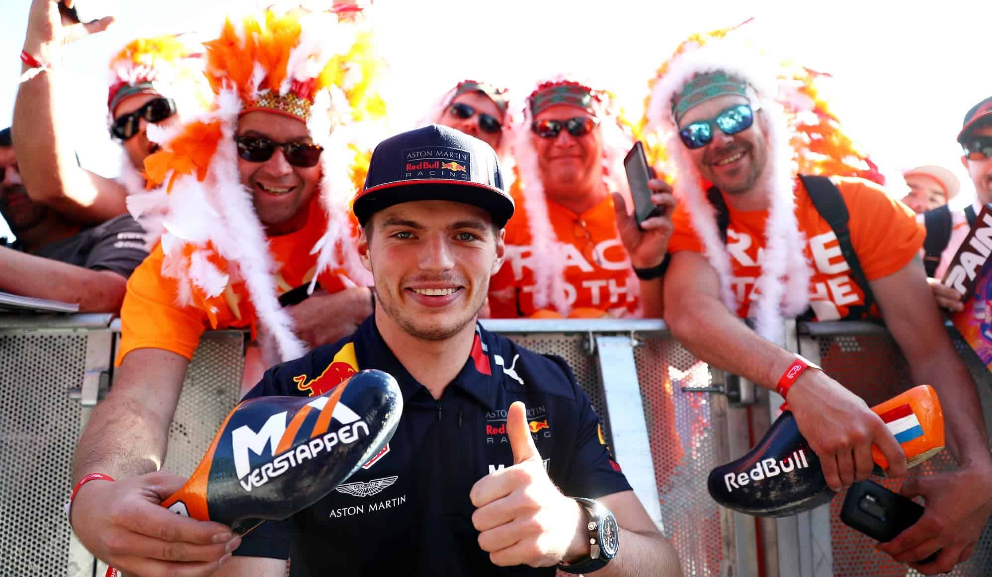 Max Verstappen posing infronf of the camera with fans behind him