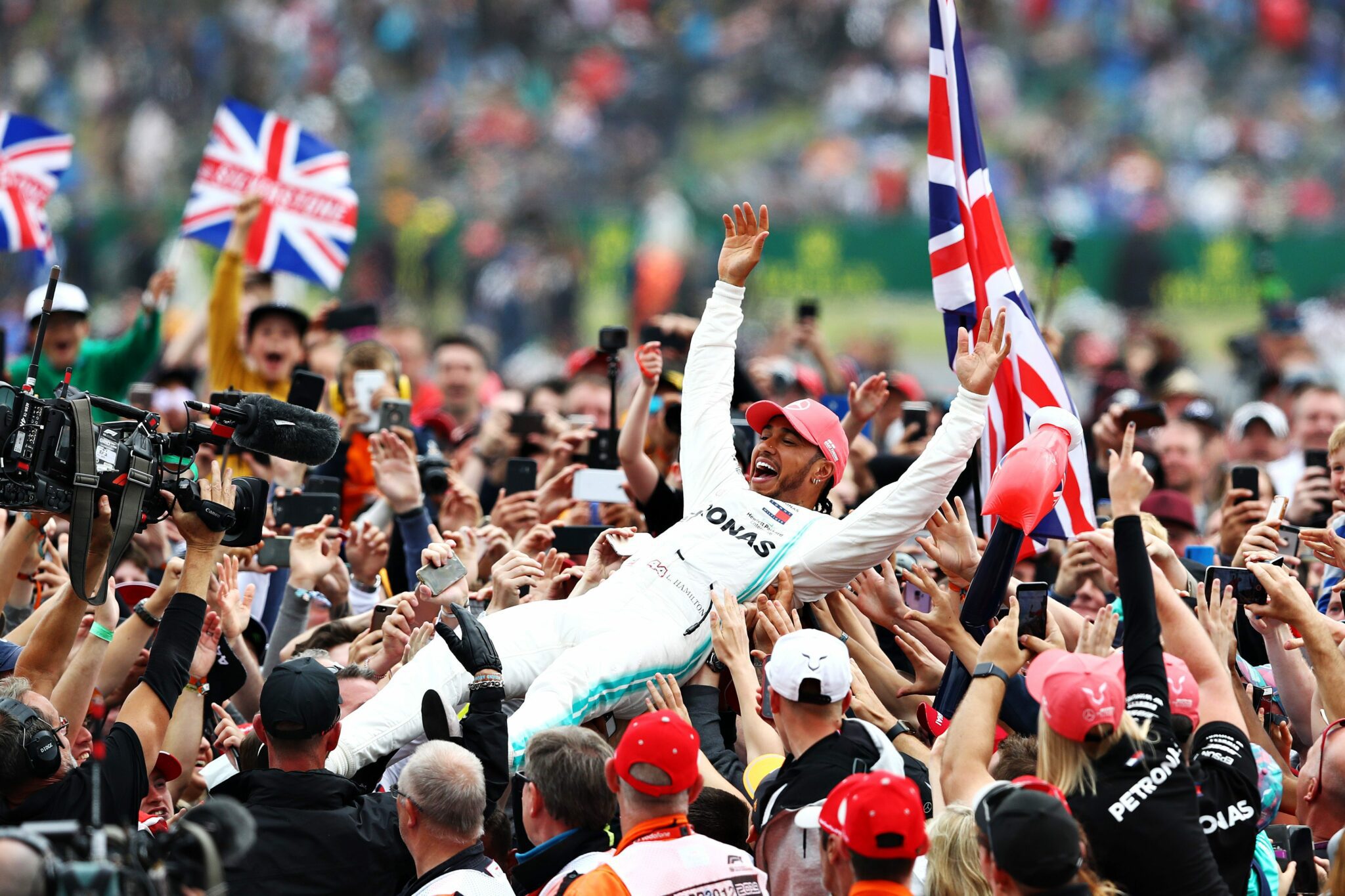 Image of Lewis Hamilton being lifted up by the crowd with british flags held up