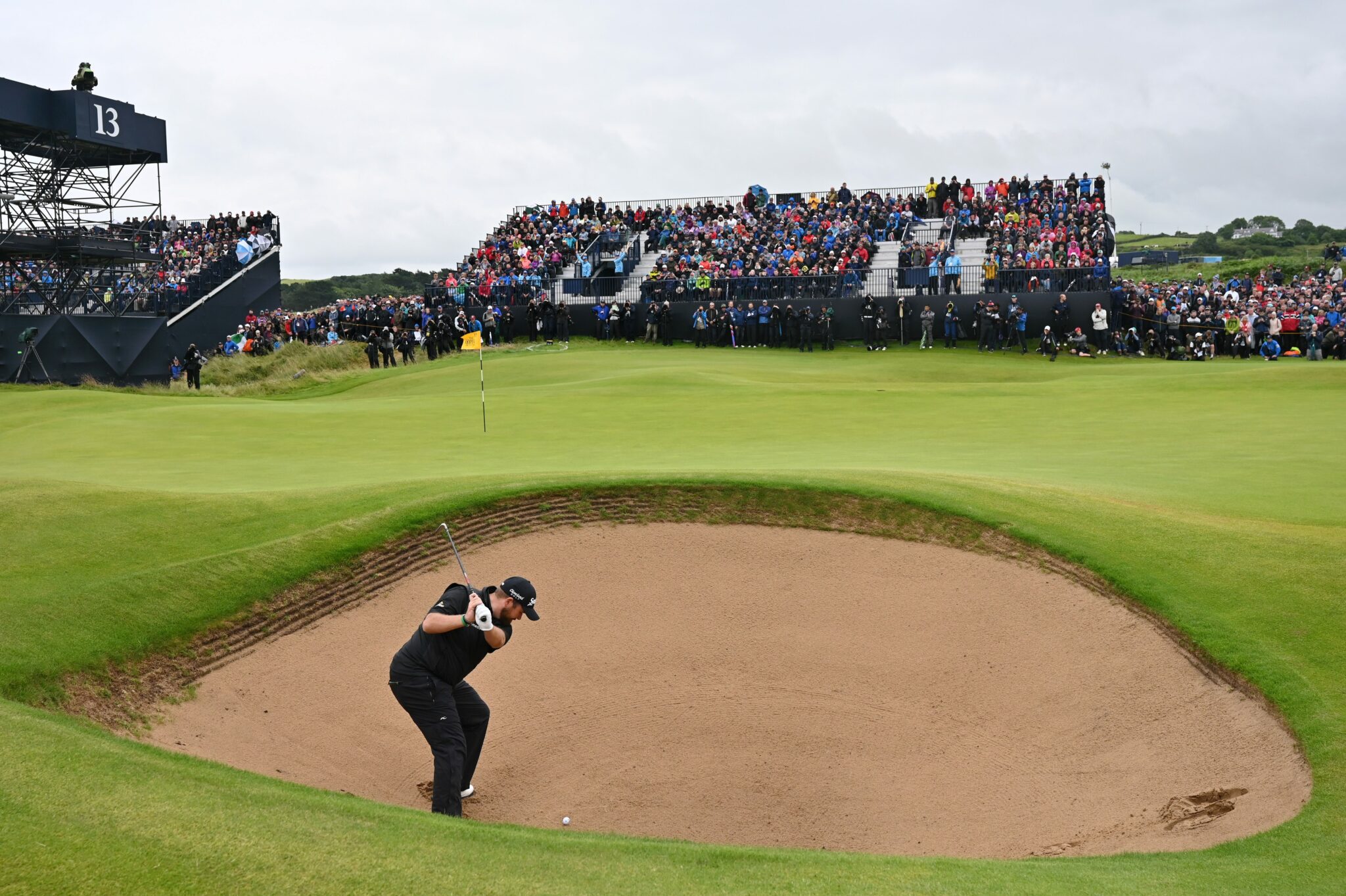 Golfer at The Open taking position on the course before play infront of a large crowd