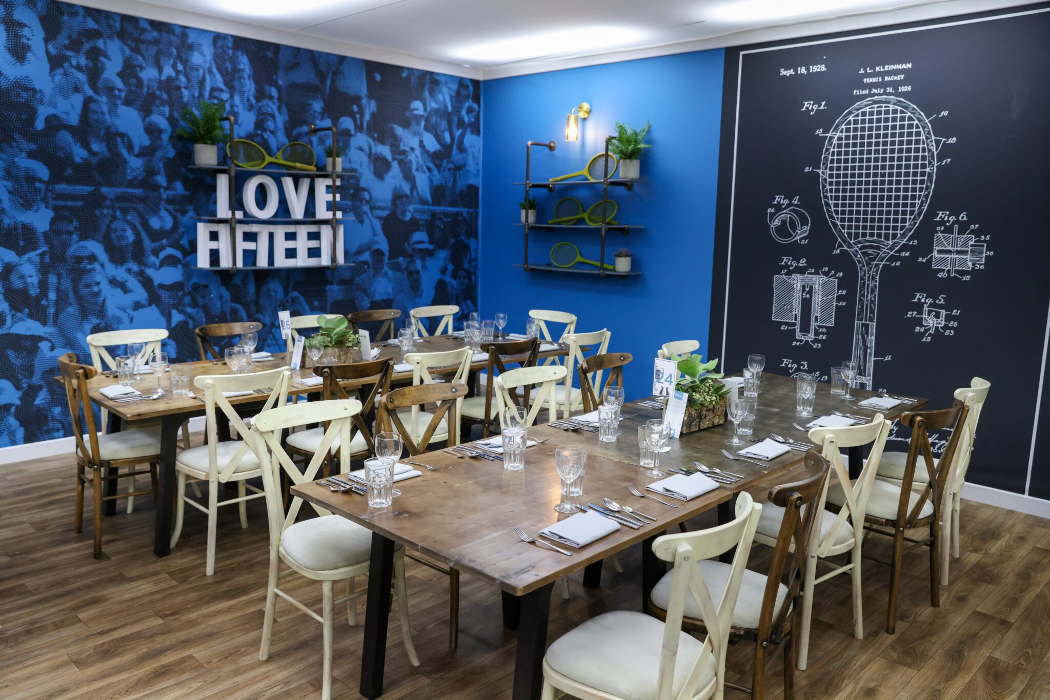 Image of the blue Love Fifteen restaurant with tables and chairs layed out