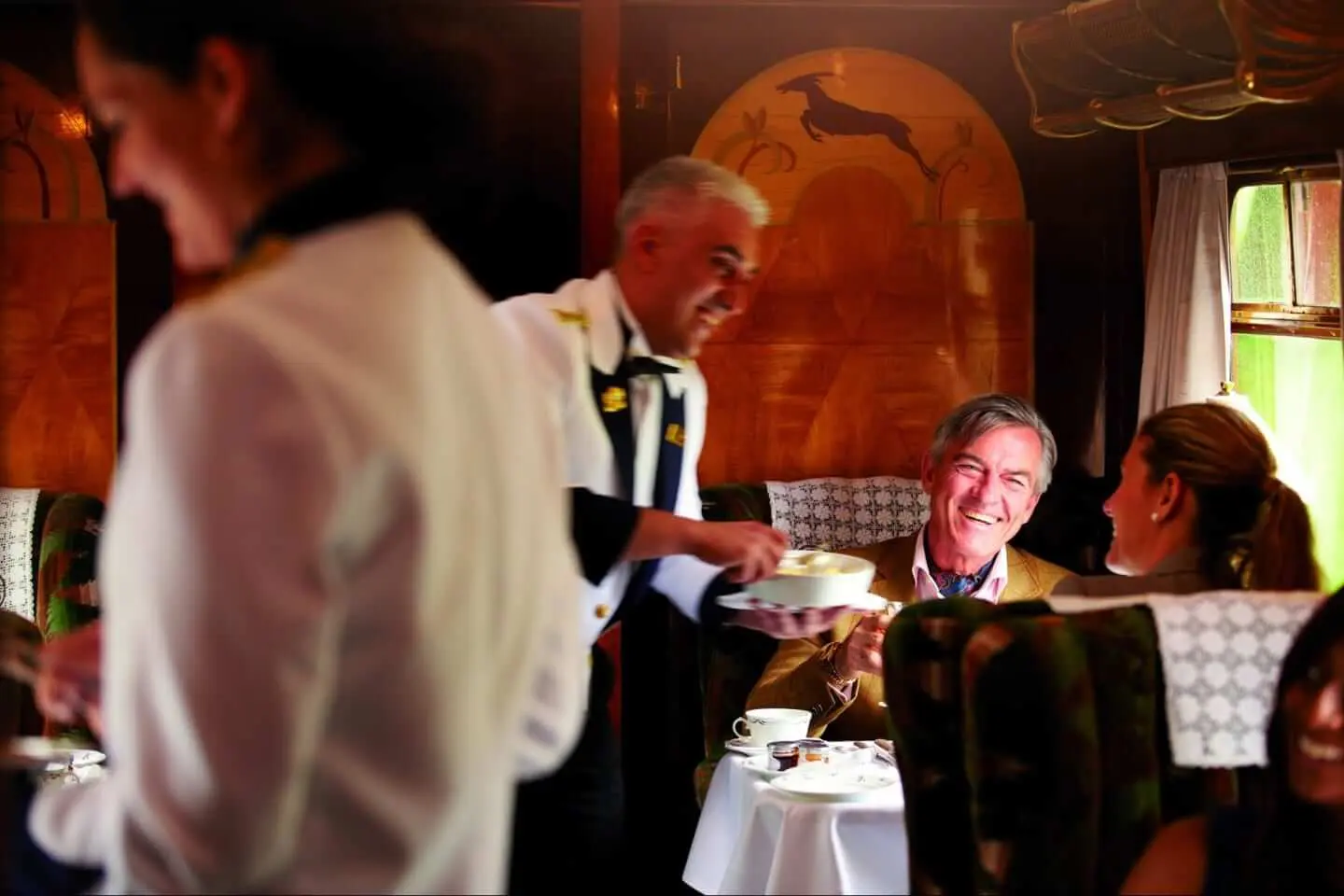 Image of male waiter serving guests on the British Pullman