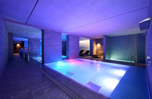 Image of the hotel's indoor pool lit up with coloured lights