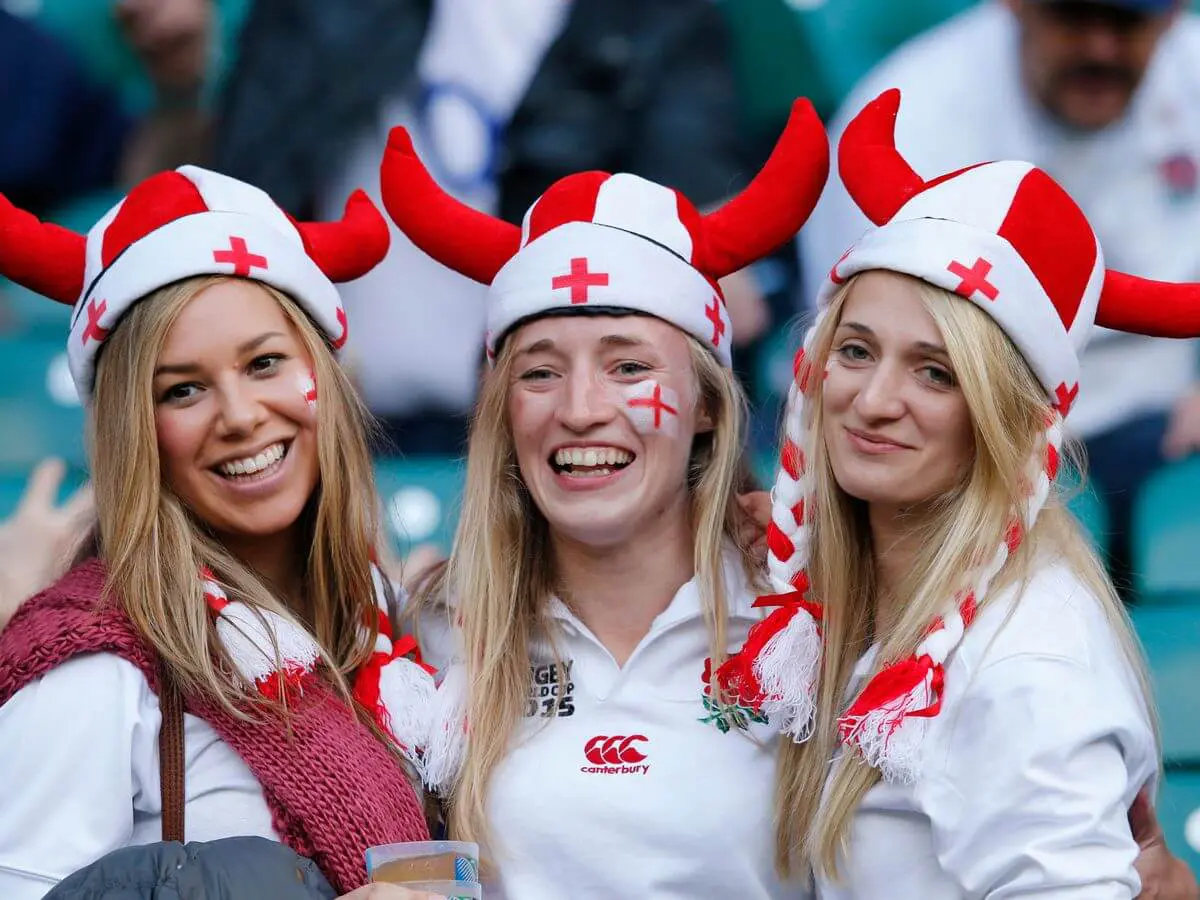 Image of three ladies dressed up watching the rugby game