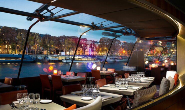 set up tables on the private boat overlooking a beautiful body of water in Paris