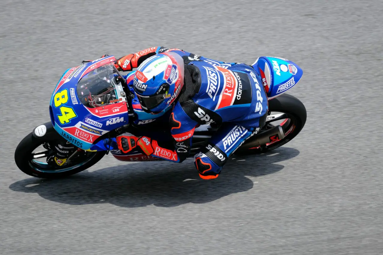 motorbike racer in red and blue low to the race track