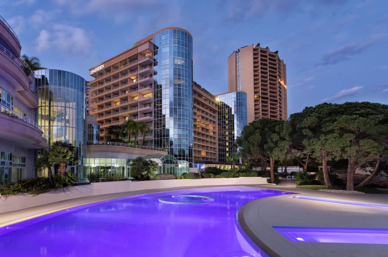 Image of the outdoor hotel pool, lit up purple at night