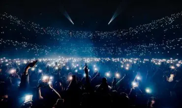 Image of people lighting up their phones to a band at the O2 Arena in London