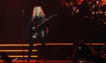 Madonna performing on stage with guitar