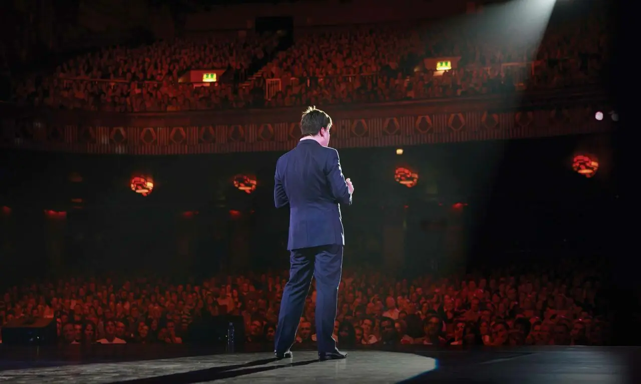 Michael Mcintyre stading in front of sold out venue